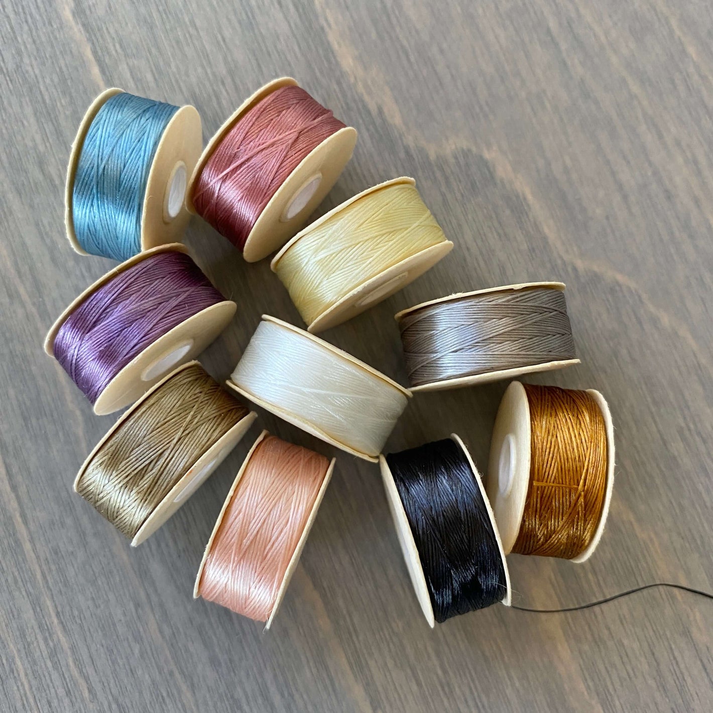 bobbins of Nymo beading thread in various colors