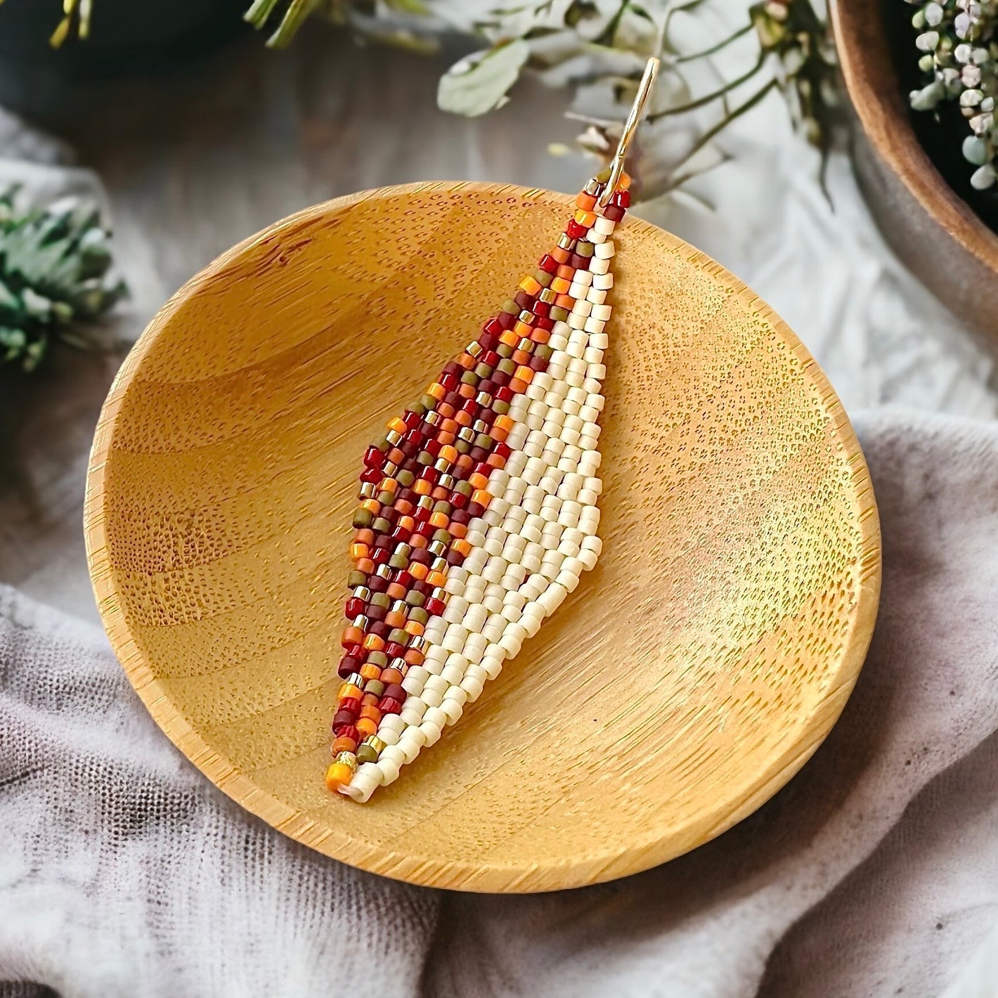 Diamond-shaped brick stitch beaded earring made with 11/0 Miyuki delica beads in autumn colors and off-white