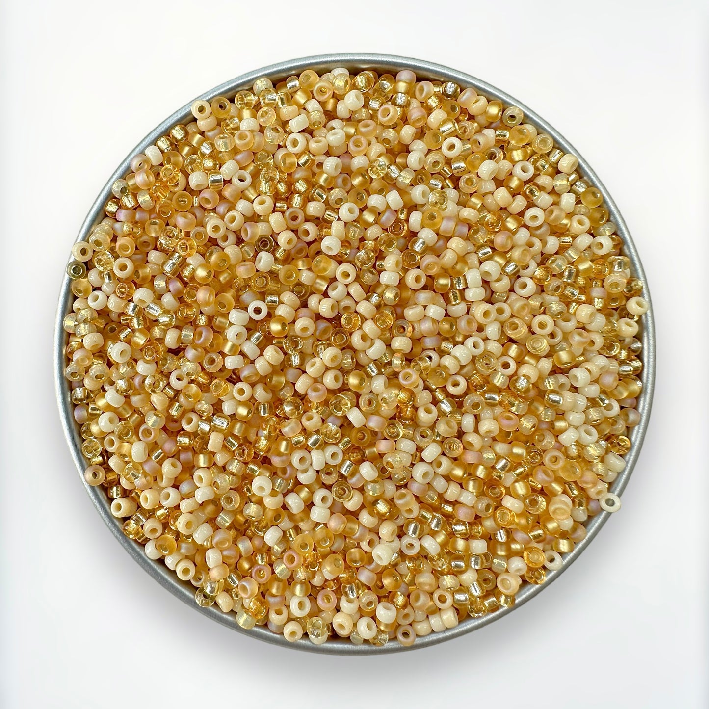 mix of cream, topaz and gold Miyuki 11/0 seed beads created by The Bead Mix in a round silver tray with a white background