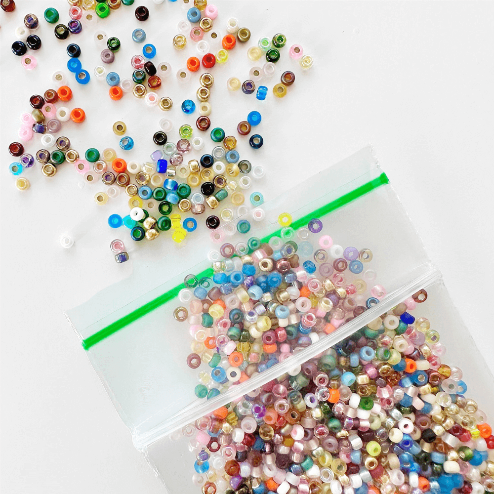 Multicolor 11/0 Miyuki seed beads spilling out of a plastic baggie.