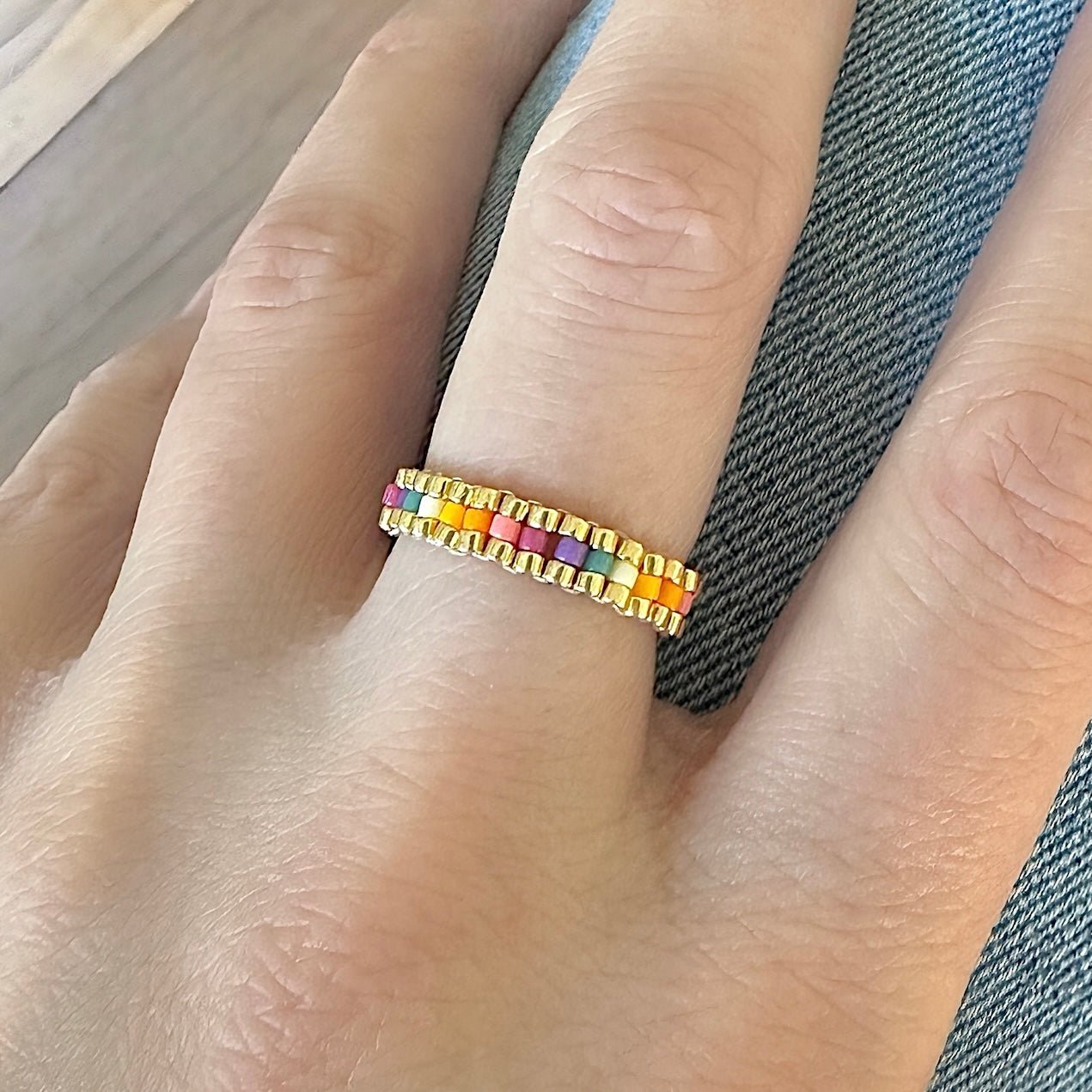 An ring made with Miyuki seed beads in shades of pink, orange, yellow, and gold. Tropical Punch Miyuki Bead Color Palette.