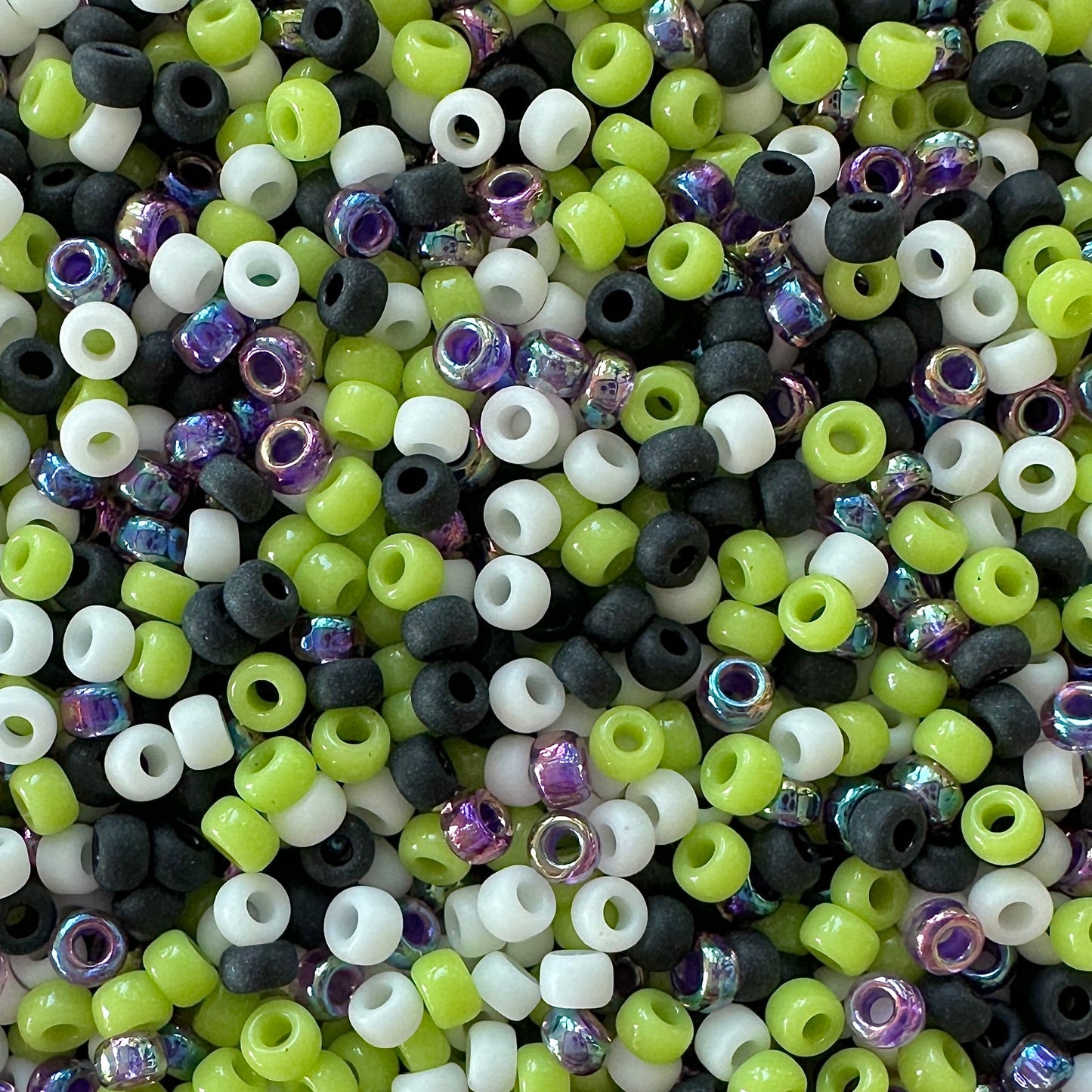 Mix of purple, black, white, and green Miyuki 11/0 seed beads by The Bead Mix