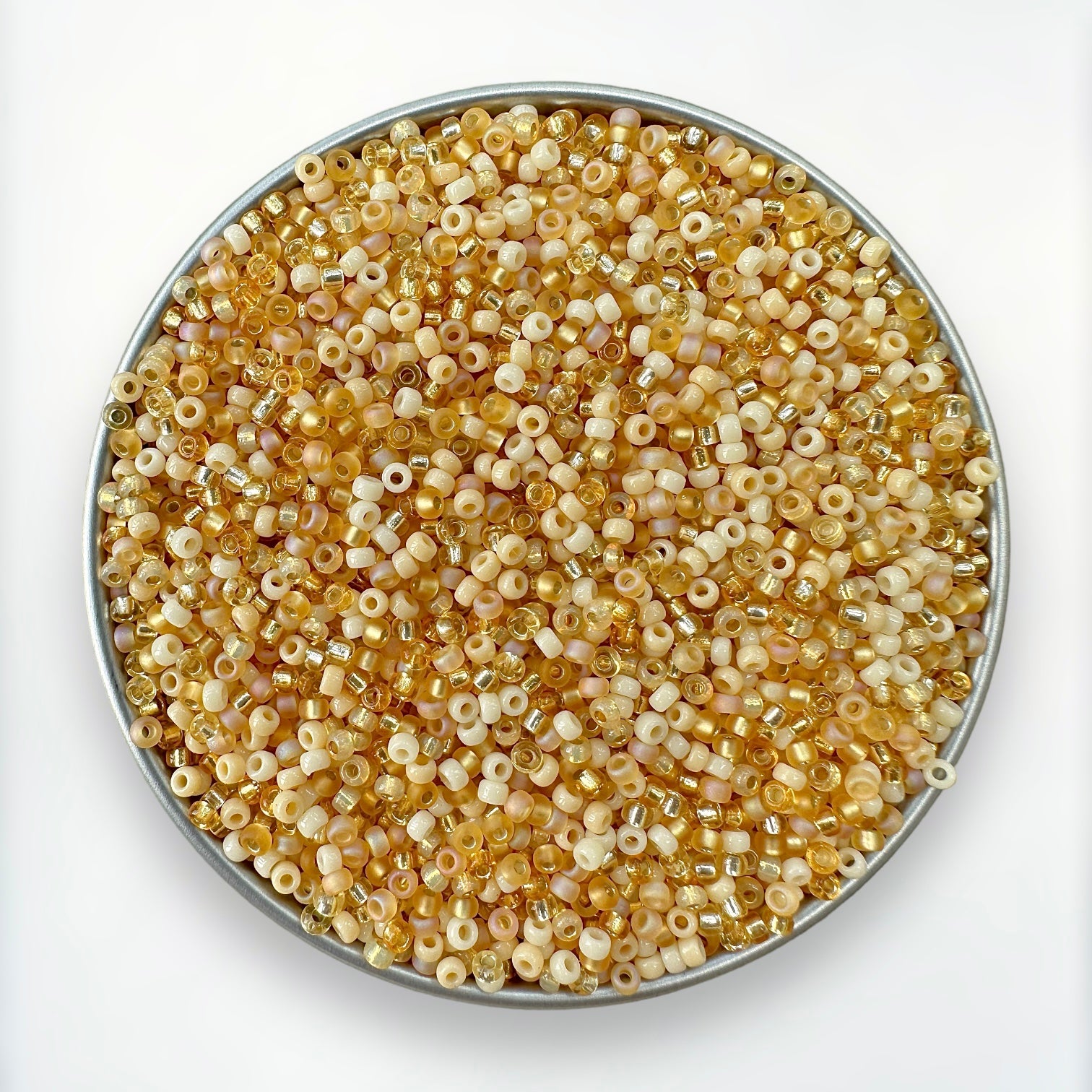 mix of cream, topaz and gold Miyuki 11/0 seed beads created by The Bead Mix in a round silver tray with a white background