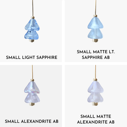 Four hanging beaded Christmas tree charms in purple and blue arranged in a 4x4 grid on a light gray background.