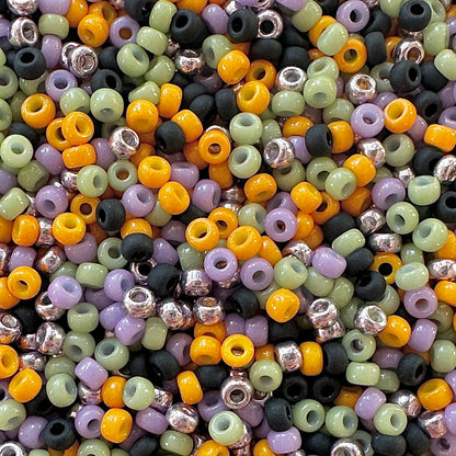 Mix of Miyuki round seed beads in faded halloween colors including black, orange, green, and purple.