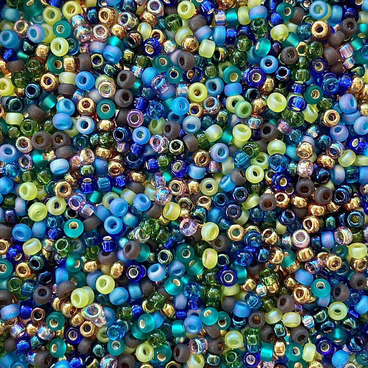 Mix of Miyuki seed beads in shades of green, blue, purple, brown, and gold.