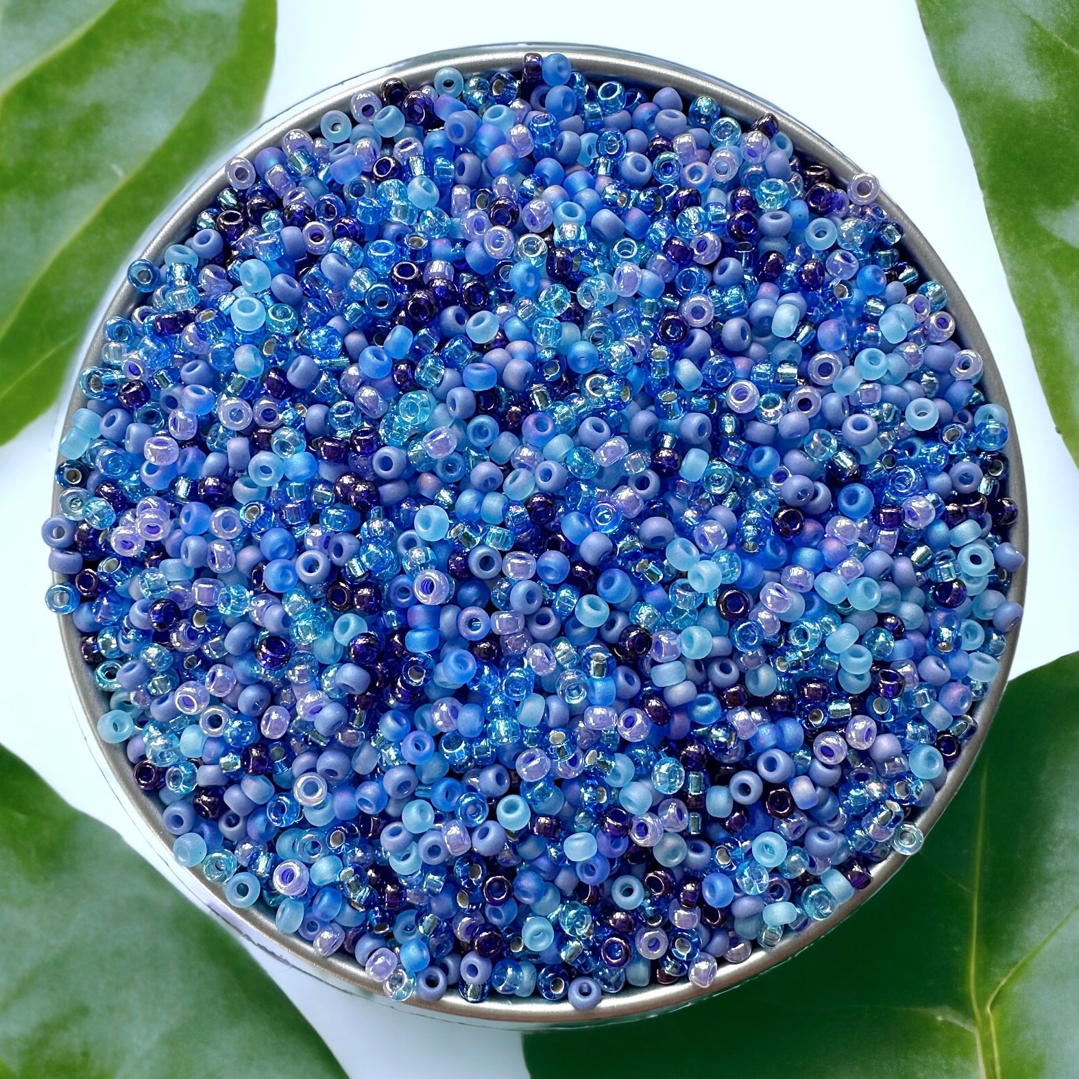 Video of pouring blue Miyuki 11/0 seed beads in a white ceramic dish on a white wood surface
