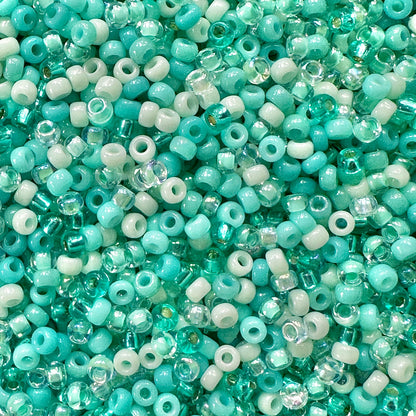 A mix of Miyuki round seed beads in shades of teal green, aqua, and mint green.